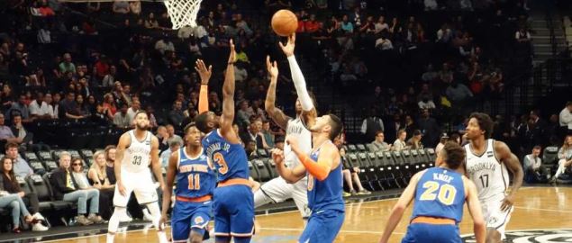 Nets guard D'Angelo Russel going up for a shot over Knicks guard Tim Hardaway Jr.